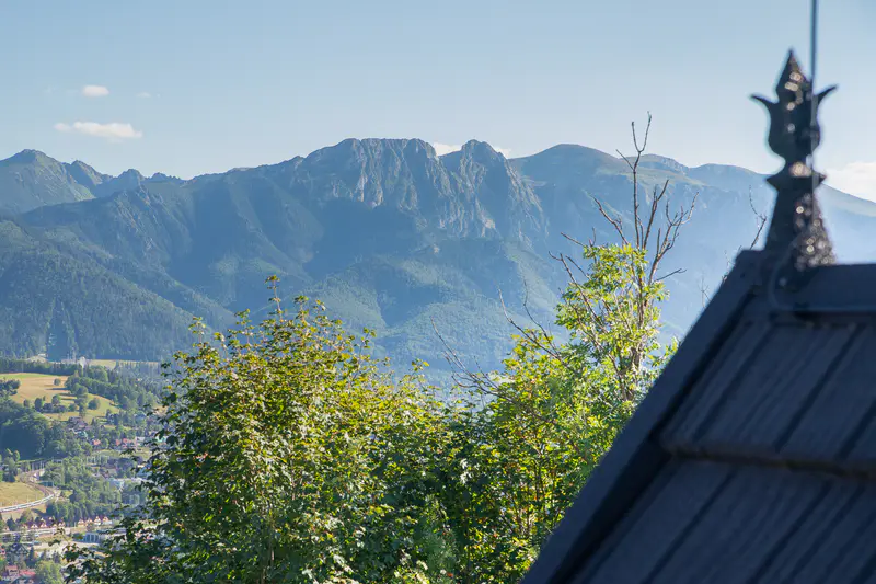 Panorama Tatr z charakterystycznym pazdurem na dachu w tle